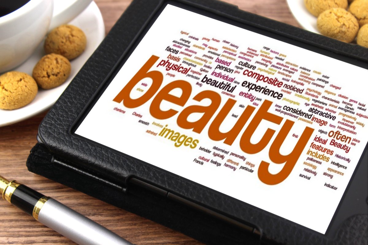 A picture of a tablet with a large sized word "beauty" and different sized relevant words surrounded, such as images, ideal features, physical, and attractive. 