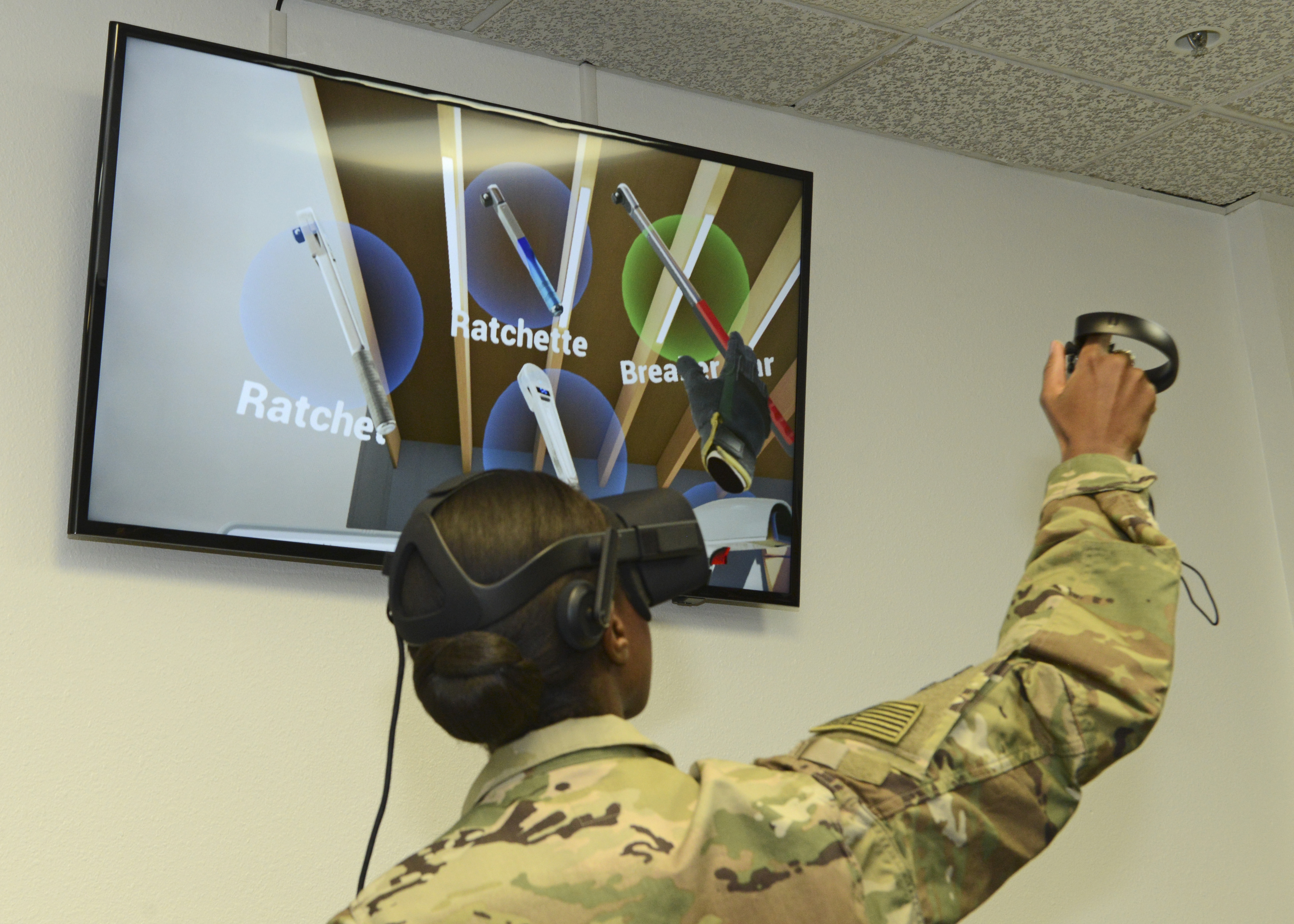 In the picture, a female is wearing the VR glasses participating to a simulation. There is a monitor connected to the VR glasses, which shows what can be seen through the glasses. There is a hand holding object at the right bottom of the screen, which represents the actual hand movement of the participant. In other words, the participant will feel like she is actually in the situation given and experiencing like reality. 